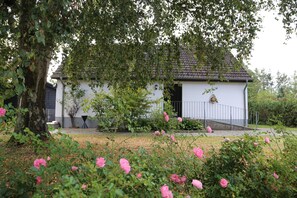 Guests can enjoy a peaceful stay in this charming single-story building surrounded by lush greenery.