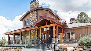 A two-story building with a stone facade, a wooden porch, and a sign reading "Oxbow Inn."