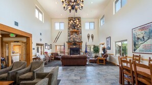A spacious lobby with a stone fireplace, leather sofas, and a chandelier.