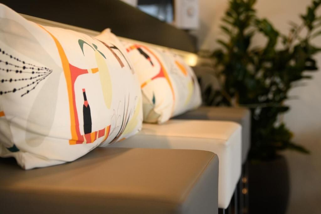 Una fila de almohadones ordenados con un diseño colorido sobre un sofá.