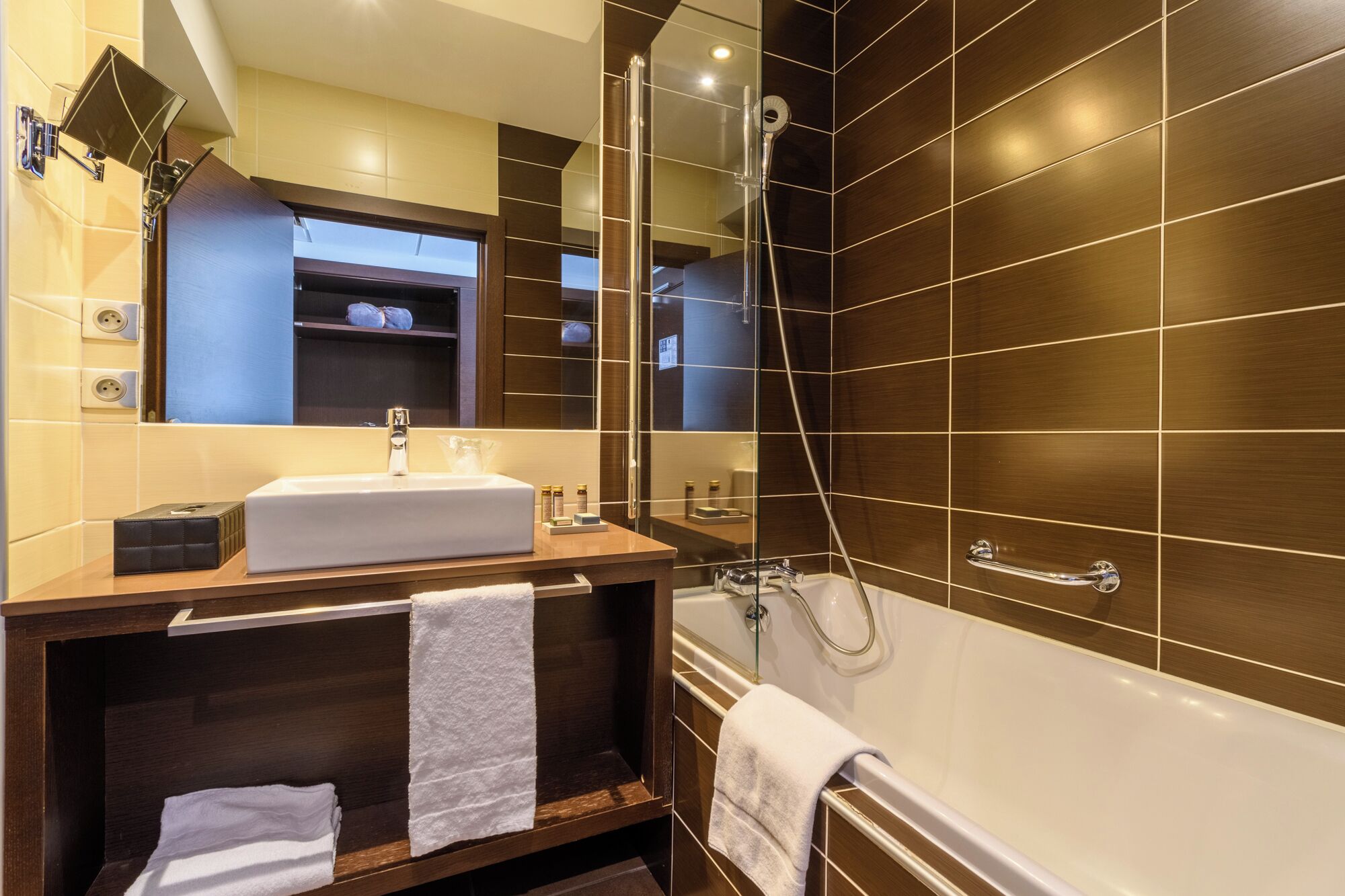 Un baño moderno con una bañera grande, un tocador con lavamanos y una zona de ducha.