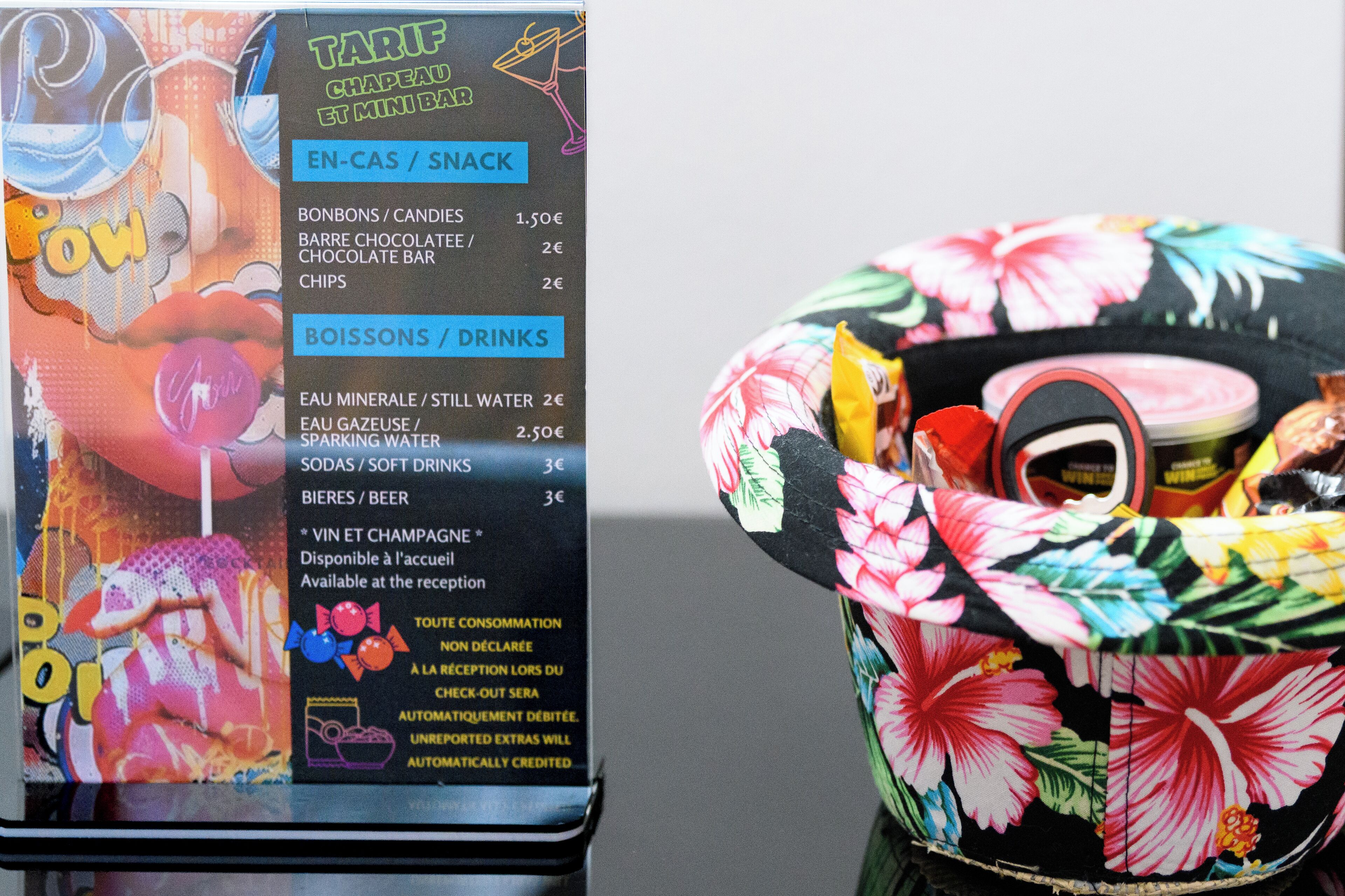 A colorful menu with prices for snacks and drinks, and a floral-patterned bag.