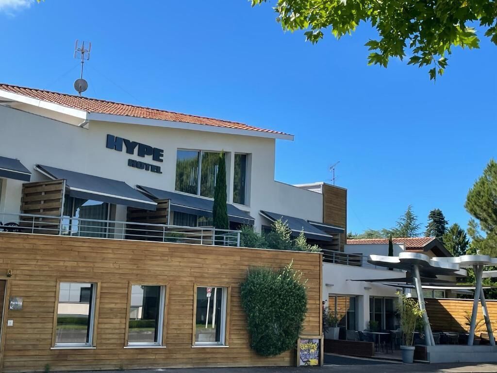 Um hotel moderno com telhado plano, grandes janelas e fachada de madeira.