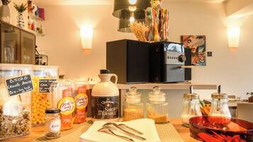 A breakfast bar with various food items, a coffee machine, and decorative elements like a colorful clown figure and wall art.