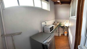 Cocina compacta con microondas, fregadero y alacenas.