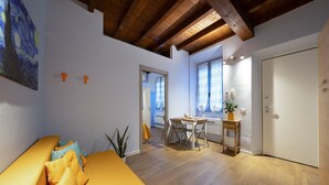 Een moderne woonkamer met een houten plafond, een eethoek met een tafel en stoelen, en een witte deur.