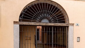 Een gevel met een metalen poort, een stenen trap en een nummer '28'.