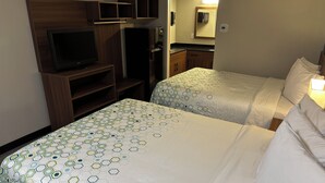 Une chambre d’hôtel avec deux lits, une télévision, un réfrigérateur et un four à micro-ondes.