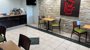 Ein Essbereich des Red Roof Inn mit Steinwand, Flachbildfernseher und einem Buffet.