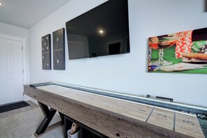 A room with a pool table, a door, and two wall-mounted paintings. - NEW Mountain Game Room Getaway (Bozeman)
