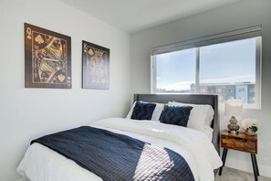 A bedroom with a bed, a window, and two wall-mounted paintings. - NEW Mountain Game Room Getaway (Bozeman)