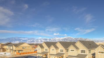 A row of residential buildings with a mountainous backdrop.