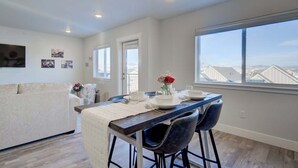 A modern kitchen with a dining area, featuring a large window with a view of the cityscape. - NEW Mountain Views | Hot Springs | Truck Stop (Bozeman)