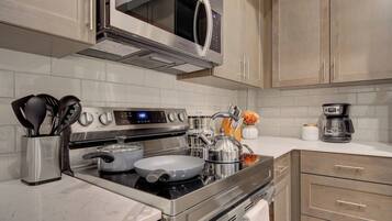 A modern kitchen with stainless steel appliances, including a microwave, stove, and coffee maker.