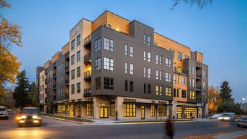 A multi-story building with a modern architectural design, featuring balconies and large windows.