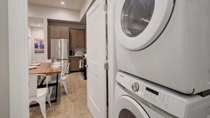 A compact kitchen with a dining area, a washing machine, and a refrigerator. - Downtown Luxury Loft | Extreme Walkability (Bozeman)