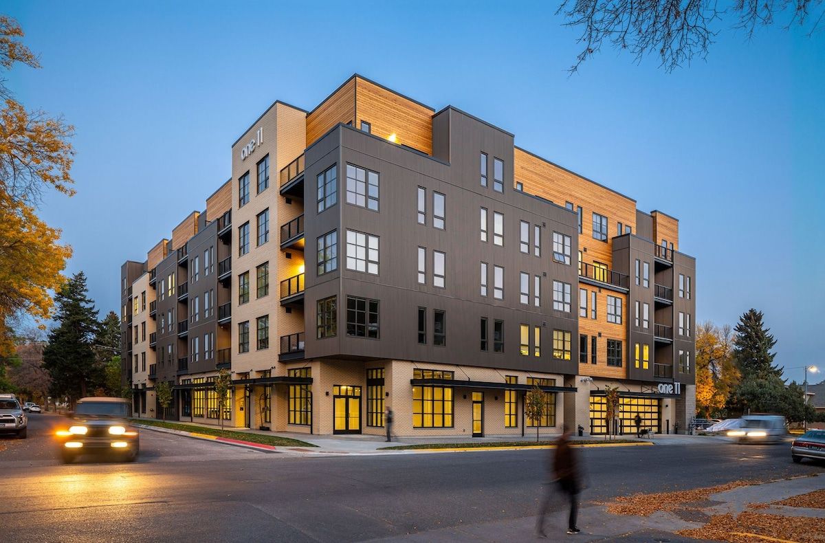 Un immeuble à plusieurs étages doté d’une architecture moderne, caractérisé par un mélange de balcons et de grandes fenêtres.