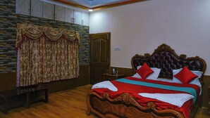 A bedroom with a wooden bed, a stone wall, and a door. - Astha Home Stay (Kodaikanal)