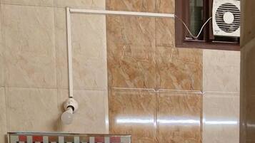 A bathroom with a sink, mirror, towel rack, and a shower.