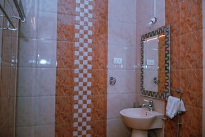 Un baño con lavamanos, espejo, toallero y pared de azulejos con diseño a cuadros.