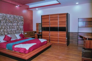 Un dormitorio moderno con una cama grande, un armario de madera y un escritorio.