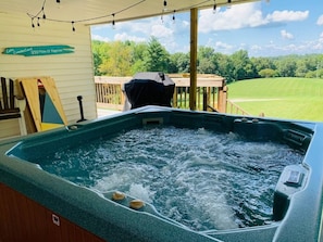 Un bain à remous avec une terrasse en bois et un panneau indiquant : « Lacs Cumberland, 1255 miles de bonheur ».
