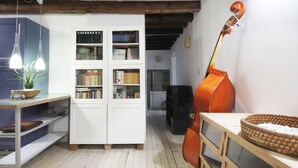 A room with a cello, a bookshelf, and a wooden table. - Spacious apartment in Venice (Venezia)