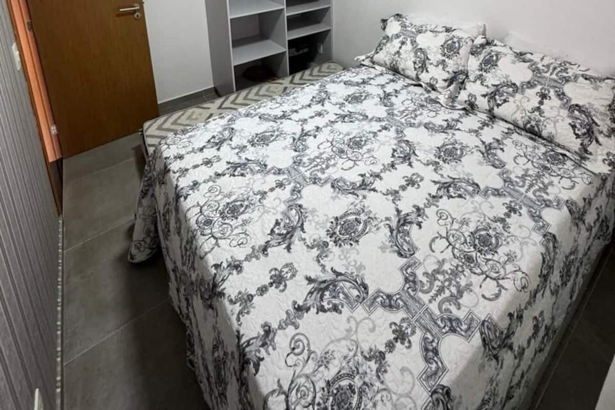 Un dormitorio con una cama, un armario y una puerta.