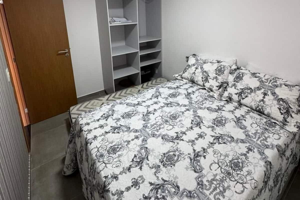 Une chambre à coucher avec un lit, une armoire et une porte.