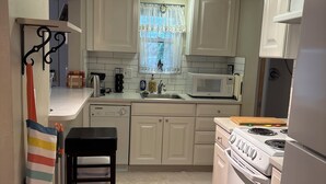 A compact kitchen with white cabinets, a microwave, a stove, and a sink. - Fabulous house with AC in charming Walla Walla (Walla Walla)
