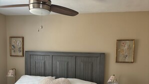 A bedroom with a bed, a nightstand, a lamp, a clock, and a ceiling fan. - Fabulous house with AC in charming Walla Walla (Walla Walla)