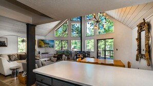 A spacious kitchen with a large island, a dining area, and a cozy living room with a fireplace.
