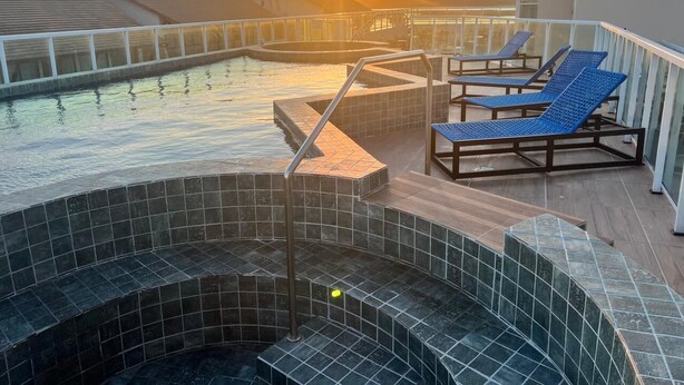 A rooftop pool with a sunset view, lounge chairs, and a hot tub. - Eco Mirage Residence by Easy Home (Ipojuca)