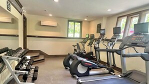 A gym with treadmills, elliptical machines, and weight benches.
