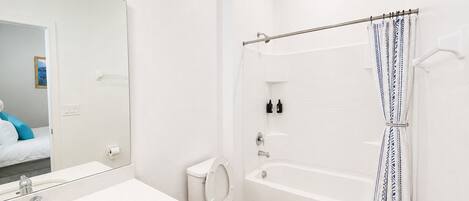 Et moderne badeværelse med vask, toilet og badekar.
