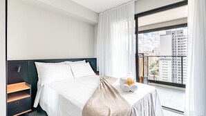 A modern hotel room with a large bed, a nightstand, a window with a view of buildings, and a balcony. - Refuge in S o Paulo With Swimming Pool Sp-p2003b (São Paulo)