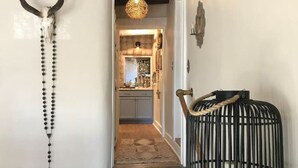 A staircase with a rustic design, leading to a kitchen area with cabinets and a hanging light fixture. - 2br Historic Adobe - 2acr Homestd A/C Exquisite NEW to VRBO! (Santa Fe)