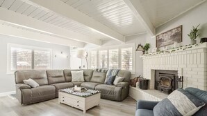 A living room with a sectional sofa, a coffee table, and a fireplace.