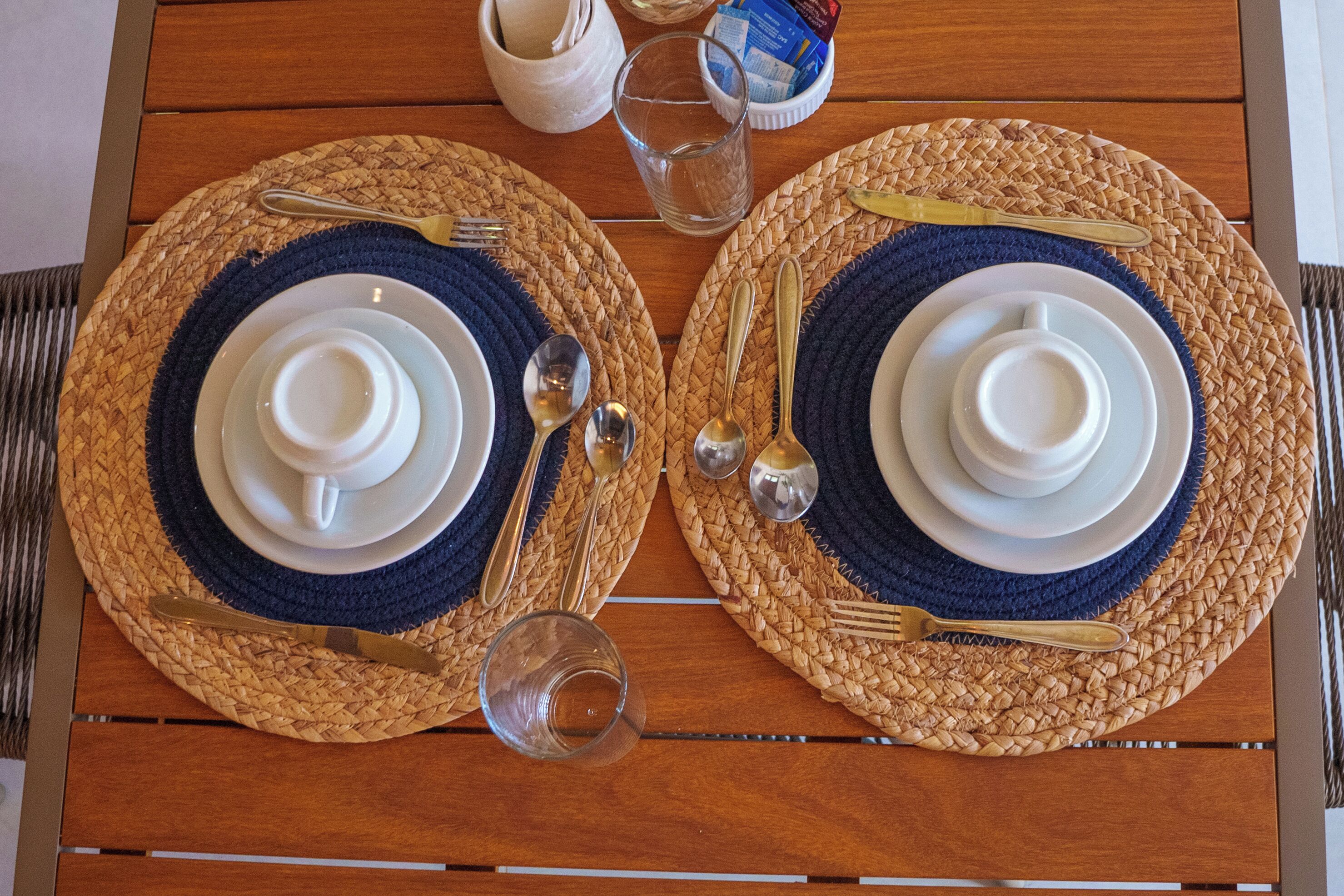 A table set with two plates, cutlery, and glasses.