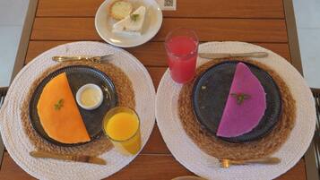 Two plates with food and drinks on a wooden table.