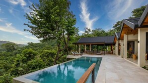 A modern poolside area with a clear view of lush greenery and a pool. - Villa Bahia (Cóbano)