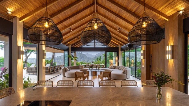 A spacious indoor area with a high ceiling, large windows, and a central seating arrangement. - Villa Bahia (Cóbano)