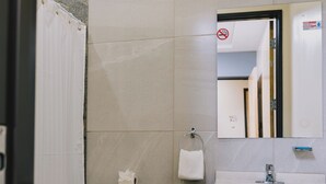 A bathroom with a toilet, sink, and mirror. - Hospedaje Consular by Dunas (Ciudad Juárez)