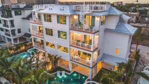 A multi-story hotel with balconies, a swimming pool, and a view of the surrounding area. - Private Beach. ROCK WALL. POOL W/ Zip Line & Slide (Sarasota)