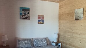 A bedroom with a large bed, two bedside tables, and wall art.