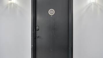 A black door with a number plate '216' and a keypad lock.