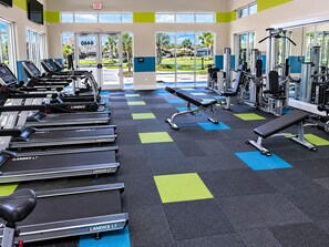 Ein Fitnessstudio mit Laufbändern, einer Bank und Krafttrainingsgeräten.
