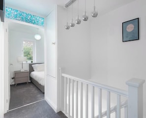 A bedroom with a bed, bedside table, lamp, and a window with a view. - 3 Bed House, Garden, Parking, Pet Friendly. (Bracknell)