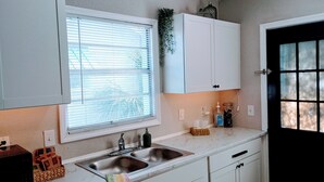 A kitchen with a window, a sink, cabinets, and a door. - 2BR/1BA near Jax Zoo -- Welcome, Train Enthusiasts!!  (Jacksonville)