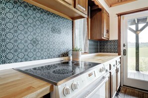 Una cocina con baldosas estampadas, estufa y armarios de madera.